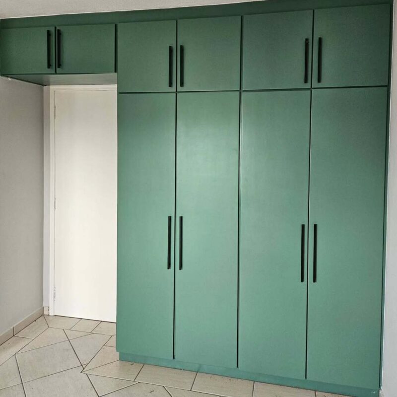Armário embutido restaurado com pintura verde laqueada e puxadores modernos.