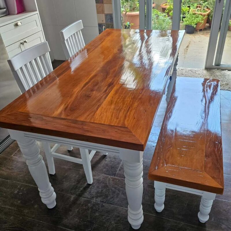 Mesa e banco restaurados com acabamento natural em verniz, destacando a madeira polida.