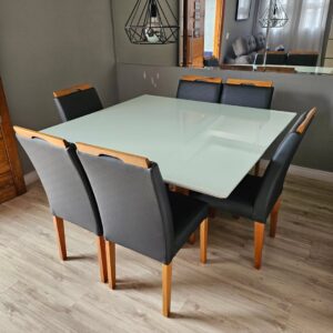 Mesa de jantar restaurada com troca de tampo em vidro e cadeiras com troca completa de tecido em preto.