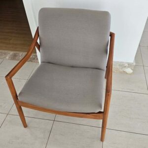 Poltrona restaurada com acabamento natural em verniz na estrutura de madeira e troca completa de tecido em cinza suave.